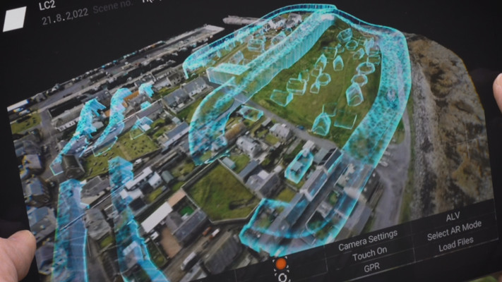 A computer-generated graphic on a monitor shows Lidar imagery of a Pictish town and ramparts layered over the modern town. (National Geographic for Disney)